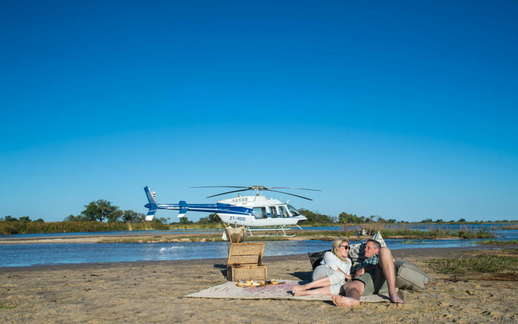 Honeymoon couple on a palm island in the Okavango Delta, Grand Africa Safaris