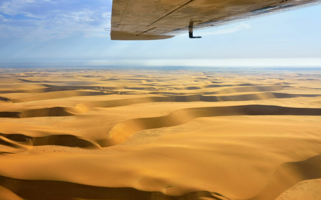 The wing of a light aircraft plane flying over Namibia